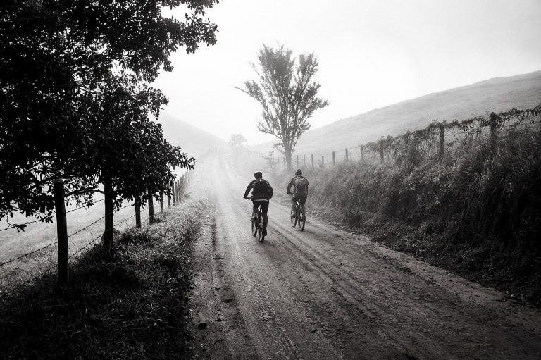 Dois jovens andando por uma trilha de bicicleta