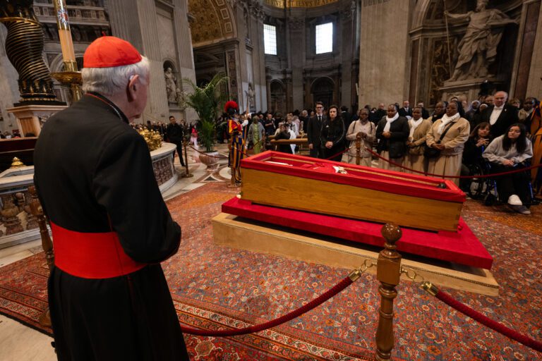 Foto do velório do apa Francisco, cercado por fieis. De costas, um padre contempla o caixão aberto. Foto: Mazur Mazur /cbcew.org.uk
