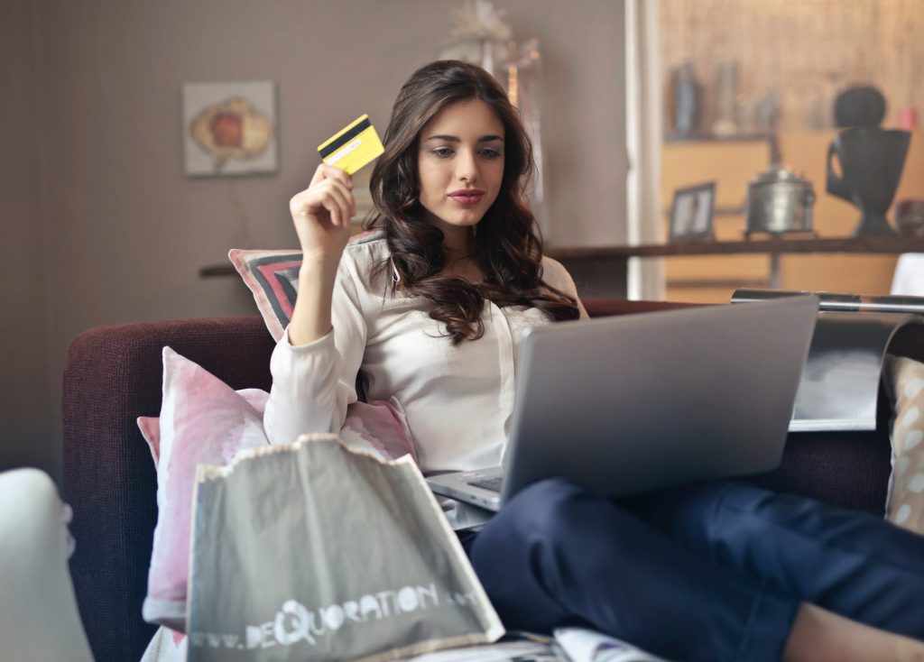 mulher diante de computador com cart&atilde;o de cr&eacute;dito na m&atilde;o simula uma compra
escola forma vendedores digitais
 Foto por bruce mars em Pexels.com