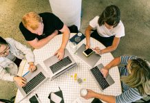 Futuro da tecnologia da informação: a concorrência do trabalho em equipes Reunião de quatro pessoas em torno de uma mesa, cada um com seu notebook. Foto por Canva Studio em Pexels.com