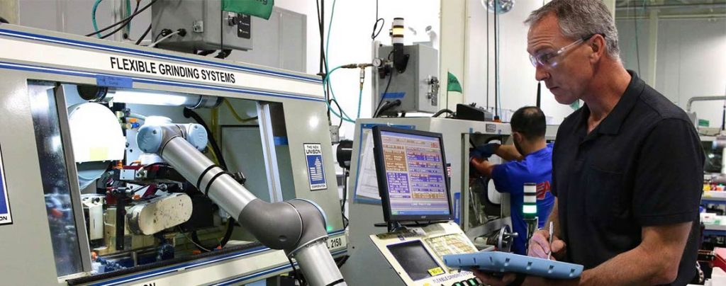 Foto mostra trabalhador produzindo com o apoio de rob&ocirc;s colaborativos.