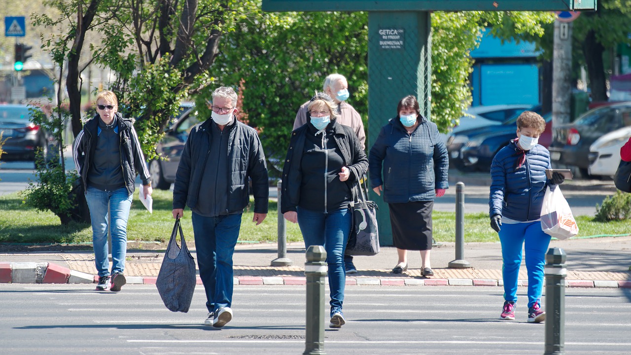 A pandemia, por meio de bloqueios e outras restri&ccedil;&otilde;es de movimento, mudou o fluxo das cidades quase da noite para o dia, e introduziu novas vari&aacute;veis para projetos de mobilidade. Foto: Pixabay - pessoas de m&aacute;scara atravessando a rua.