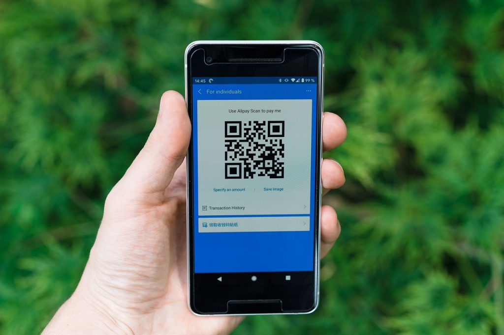 usu&aacute;rio de smartphone mostrando c&oacute;digo qr code