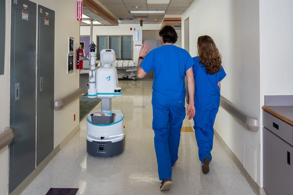 Enfermagem no futuro: Imagem mostra dois profissionais "comprimentando" um rob&ocirc; em um hospital