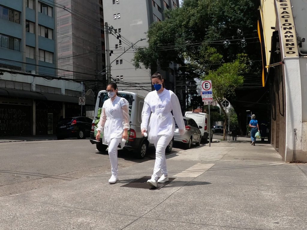 Conversas sobre o futuro: duas profissionais da sa&uacute;de, de m&aacute;scara, caminham em uma rua vazia de s&atilde;o paulo - foto: fotos p&uacute;blicas