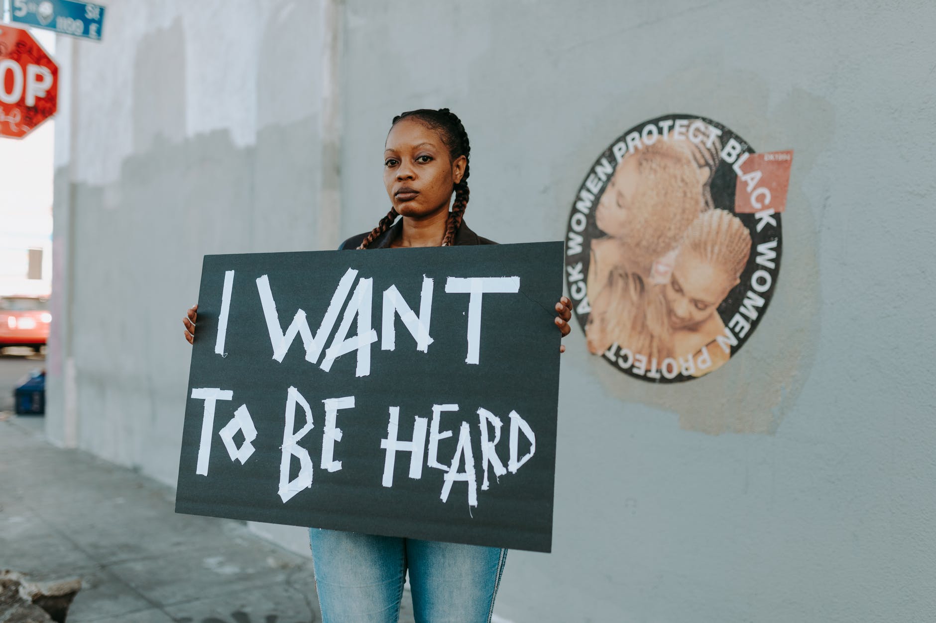 Mulher protesta na rua, reivindicando ser ouvida pela sociedade.