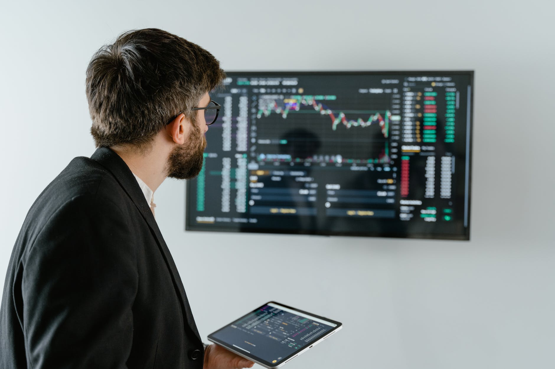 man in black suit holding a digital tablet and looking at data on screen
fintech
