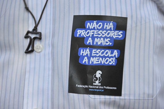 Wikimedia Commons
a reforma do ensino analisada por um professor da rede p&uacute;blica. 
foto: menino barrado em porta de escola. atr&aacute;s dele, uma faixa escrito despedidos ????