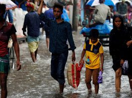 As pessoas andam sobre a água enquanto as estradas são inundadas devido a fortes chuvas em Dhaka, Bangladesh, em 26 de julho de 2017.Imagem: REUTERS / Mohammad Ponir Hossain