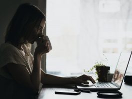 foto ilustrativa jovem mulher trabalha em frente ao computador bebendo em uma caneca Photo by Burst on Pexels.com
