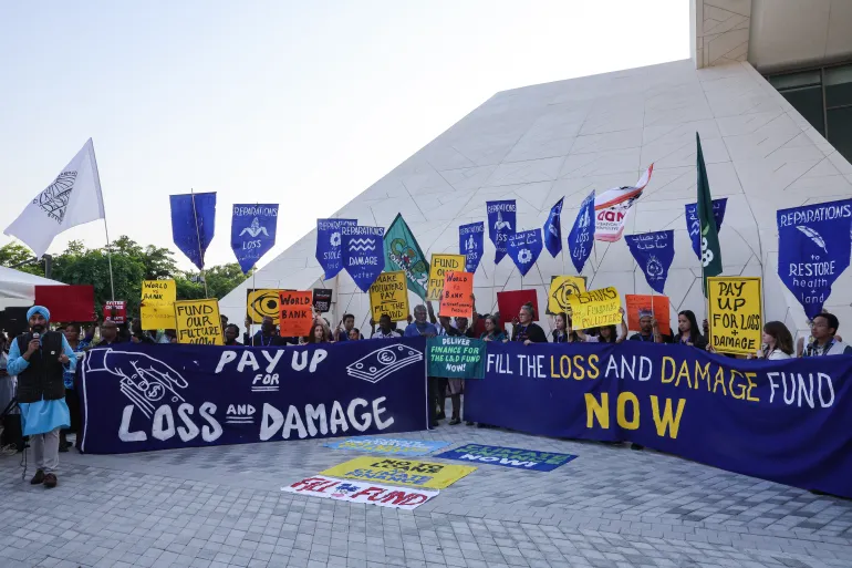 Ativistas ambientais exibem cartazes durante uma manifestação no local da cúpula climática das Nações Unidas COP28, em Dubai, em 6 de dezembro de 2023 [Giuseppe Cacace/AFP]