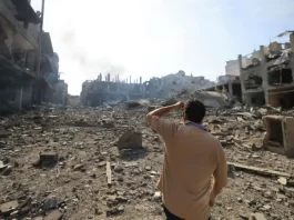 Foto de Raphael Sanz, publicada no site revista Fórum, mostra homem diante do cenário de destruição.