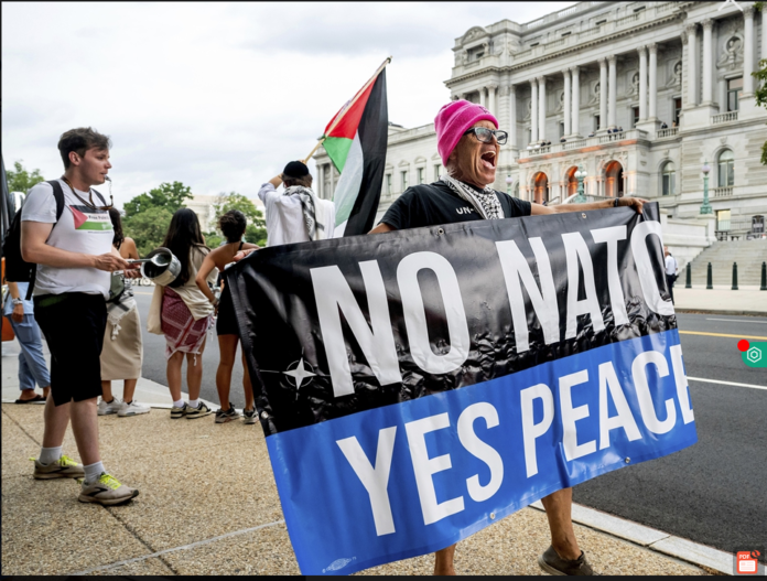 Em protesto na rua, manifestante mostra cartaz onde se lê "Não à otan, sim à paz" - Foto Global Times